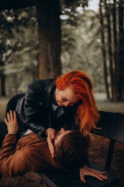 Parktaki bankta birbirine aşık bir çift poz veriyor. 