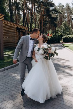 Mutlu genç gelin ve damat parkta öpüşme              