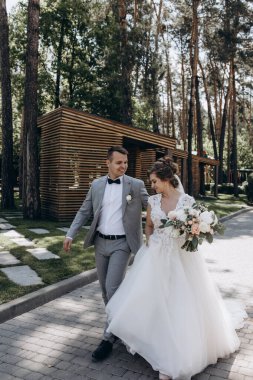 Genç ve mutlu bir çift yaz parkında yürüyor.          