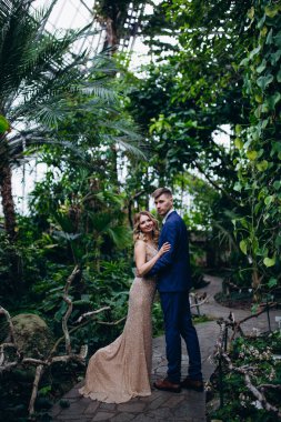 Güzel genç gelin ve parkta poz veren yakışıklı damat.