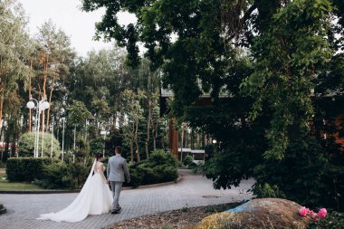 Genç ve mutlu bir çift yaz parkında yürüyor.          