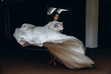 Güzel mutlu genç gelinin portresi zarif bir gelinlik tutuyor.          