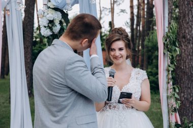 Gelin ve damat düğün gününde konuşuyor ve gülümsüyor. 