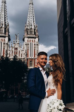 Güzel, genç, mutlu gelin ve damat düğün gününde şehirde         