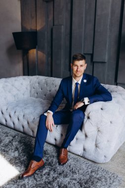 Koltukta oturan takım elbiseli yakışıklı bir iş adamının portresi.