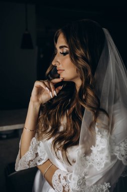 Sabahları evde poz veren beyaz cübbeli ve peçeli güzel gelinin portresi.              