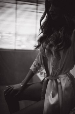 siyah ve beyaz, banyoda bornozlu güzel bir kadın resmi.