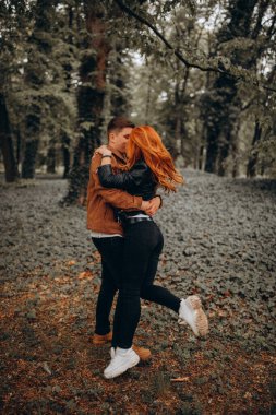 Mutlu genç çift sonbahar ormanında aşık. 