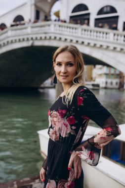 Venedik, İtalya 'daki eski kanal yakınlarında poz veren sarı saçlı güzel bir kadın.