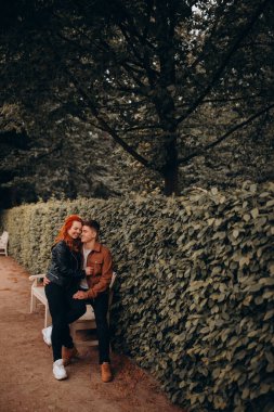 Genç ve güzel bir çift sonbahar parkında poz veriyor. 