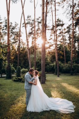 Mutlu genç gelin ve damat parkta öpüşme              