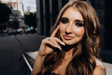 Gelinlikli çekici gelinin portresi şehirdeki kameraya bakıyor.    