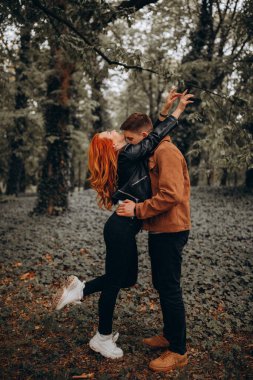 Mutlu genç çift sonbahar ormanında aşık. 