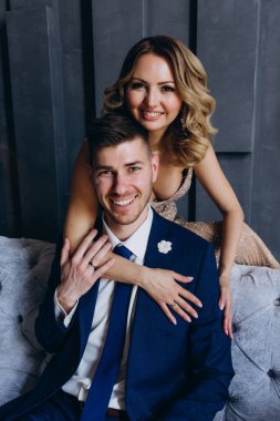 Birbirlerine aşık güzel bir çift stüdyoda koltukta poz veriyor.