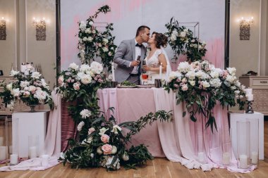 Düğün resepsiyonunda mutlu bir çift öpüşüyor.