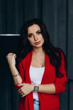 Lambanın yanında kırmızı ceketli güzel esmer kadın poz veriyor. 