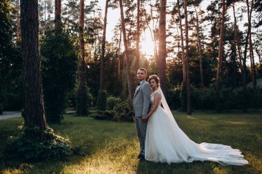 Parkta poz veren mutlu gelin ve damat çifti     