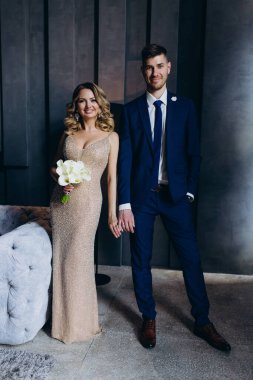 Gelin ve damat stüdyoda poz veriyor. 