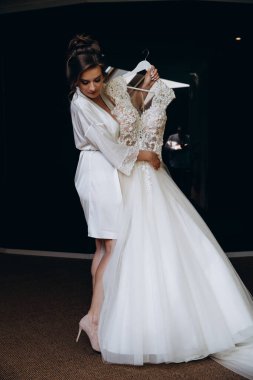 Güzel mutlu genç gelinin portresi zarif bir gelinlik tutuyor.          