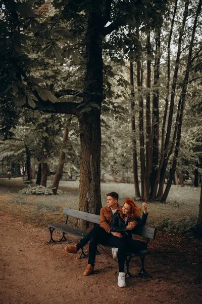 Genç aşıklar parkta bankta oturuyor.