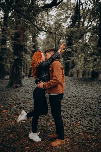 Mutlu genç çift sonbahar ormanında aşık. 