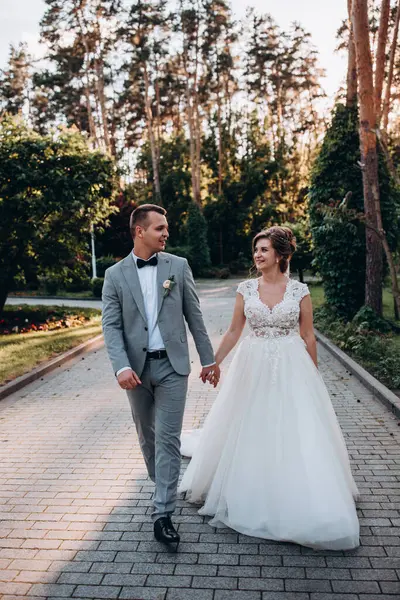 Genç ve mutlu bir çift yaz parkında yürüyor.          