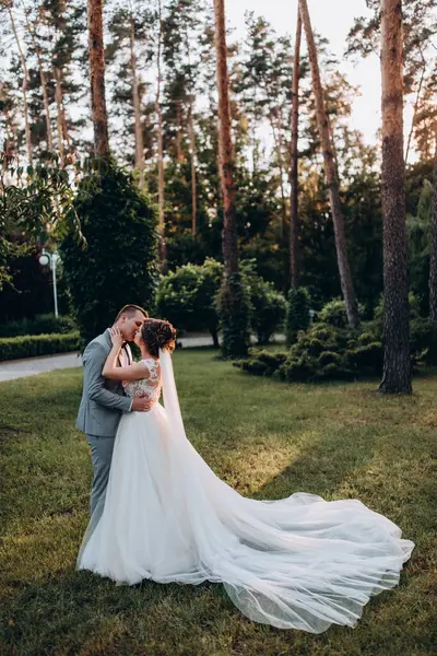 Mutlu genç gelin ve damat parkta öpüşme              