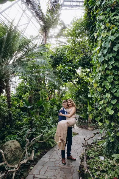 Genç çift tropikal bahçede poz veriyor. 