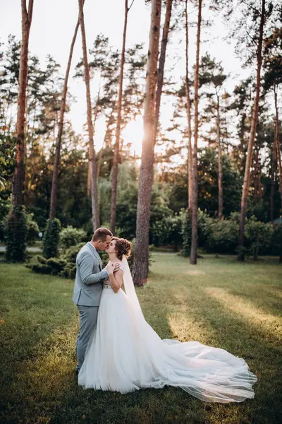 Mutlu genç gelin ve damat parkta öpüşme              