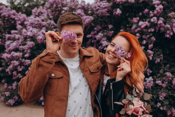 Mutlu çift baharda parkta poz veriyor. 