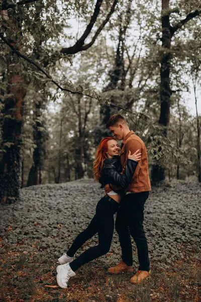 Mutlu genç çift sonbahar ormanında aşık. 