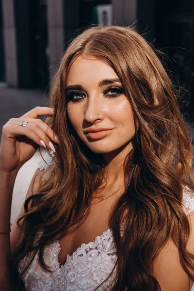 Beyaz gelinlikli güzel gelin şehirde poz veriyor.             