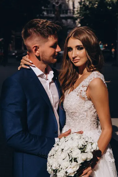 Güzel, genç, mutlu gelin ve damat düğün gününde şehirde         