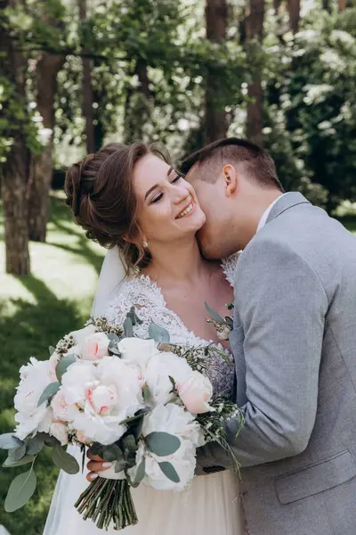 Mutlu genç gelin ve damat parkta öpüşme              