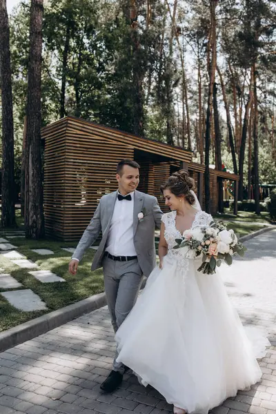 Genç ve mutlu bir çift yaz parkında yürüyor.          