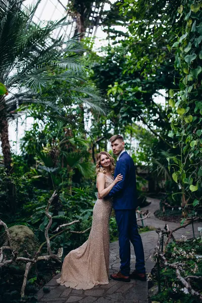 Güzel genç gelin ve parkta poz veren yakışıklı damat.