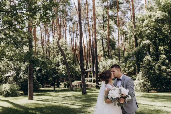 Mutlu genç gelin ve damat parkta öpüşme              