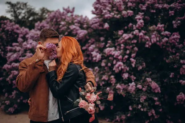 Mutlu çift baharda parkta poz veriyor. 