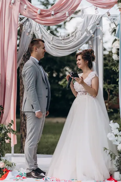 Gelin ve damat düğün gününde konuşuyor ve gülümsüyor. 