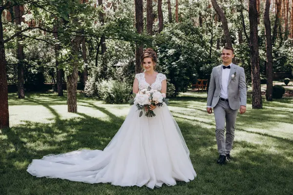 Genç ve mutlu bir çift yaz parkında yürüyor.          