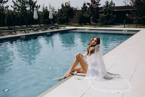 Beyaz ipek bornoz ve peçeli güzel gelinin portresi, bilardoda poz veriyor. 