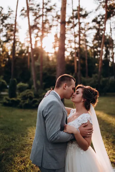 Mutlu genç gelin ve damat parkta öpüşme              