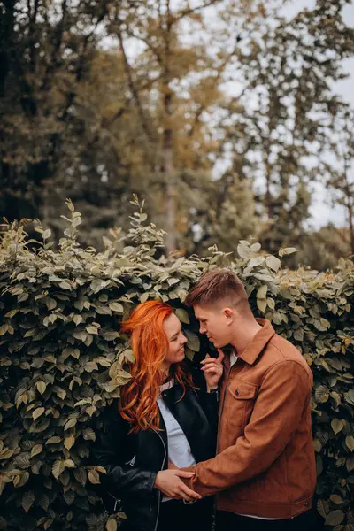 Genç ve güzel bir çift sonbahar parkında poz veriyor. 