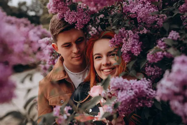 Genç çift parkta sarılıp öpüşüyor. 