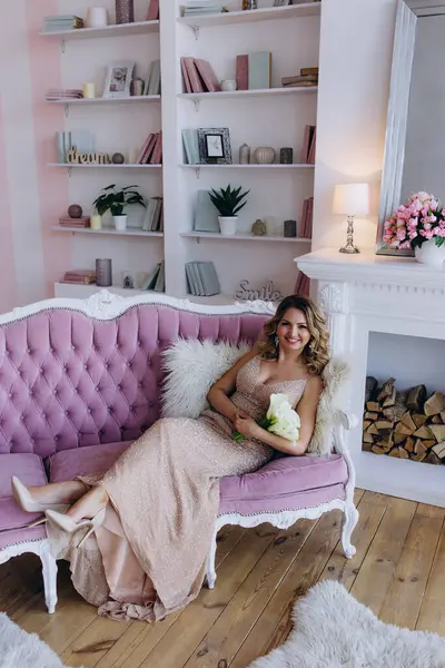 Kalla zambağı buketi tutan güzel gelin koltukta rahat bir şekilde poz veriyor. 