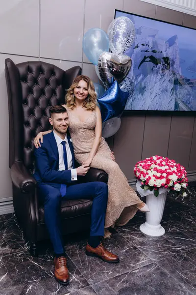 Gelin ve damat deri sandalyede poz veriyorlar. 