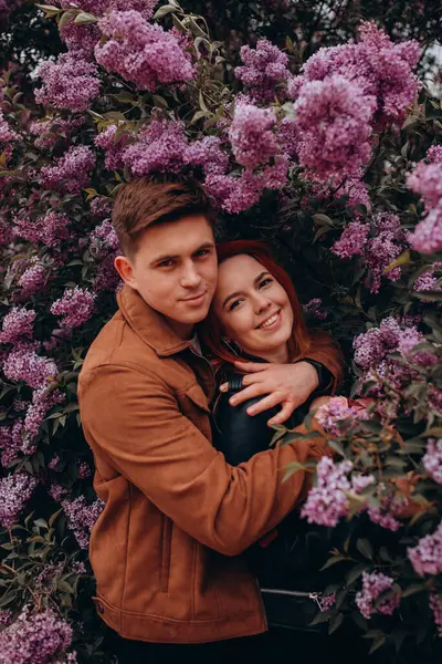 Genç çift parkta sarılıp öpüşüyor. 