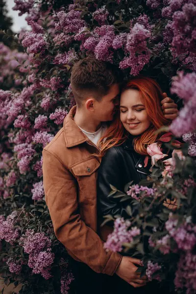 Genç çift parkta sarılıp öpüşüyor. 