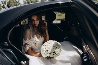 Bir buket çiçekli güzel gelin lüks bir arabayla geliyor.         