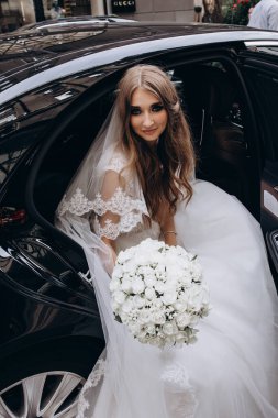 Bir buket çiçekli güzel gelin lüks bir arabayla geliyor.         